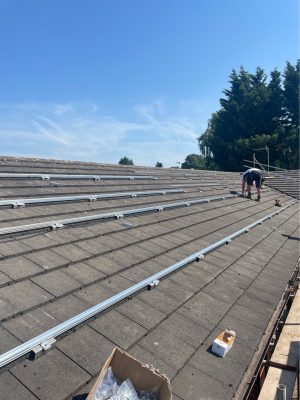 Solar Select engineer fitting roof mounting rails at Worcester Bowls Club