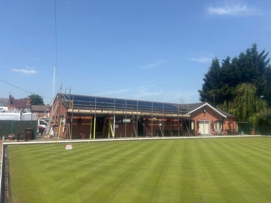 Solar panel installation in progress with scaffolding at Worcester Bowls Club